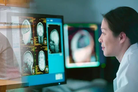 Physician looking at computer with MRI images