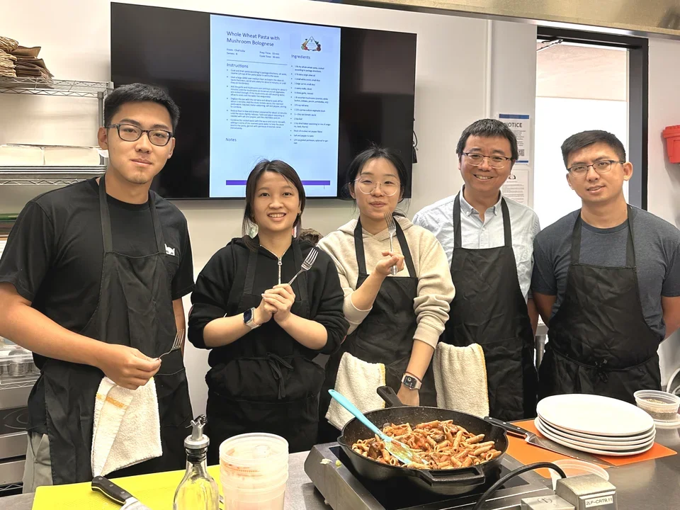 Group photo of the Zhong lab in a kitchen.